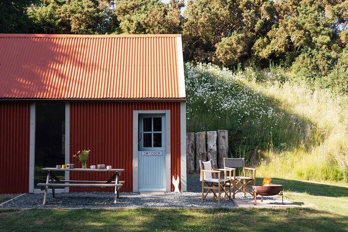 Red cabin with outdoor seating, fire put and meadow 