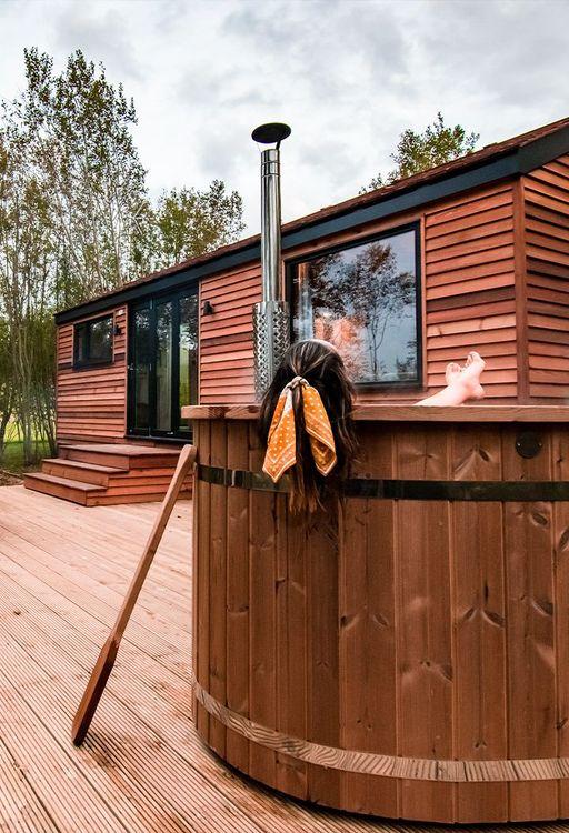 Person enjoying hot tub on decking of cabin 