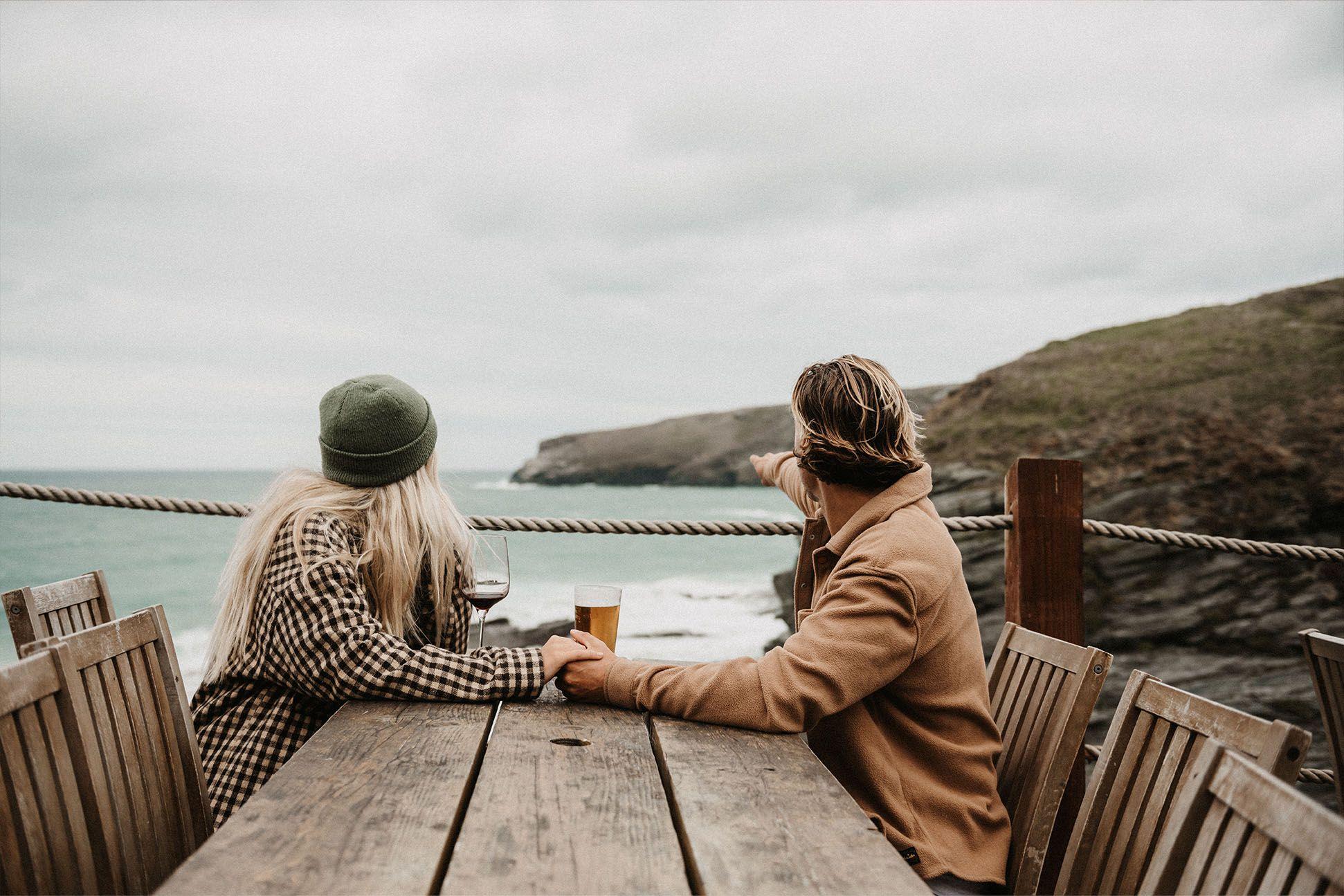 Couple sat at a table overlooking the sea