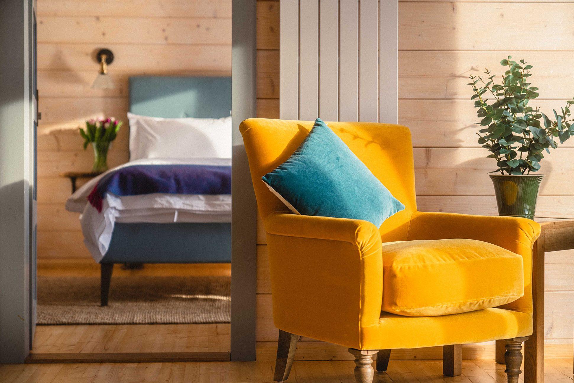 Yellow chair in front of a bedroom inside a cabin