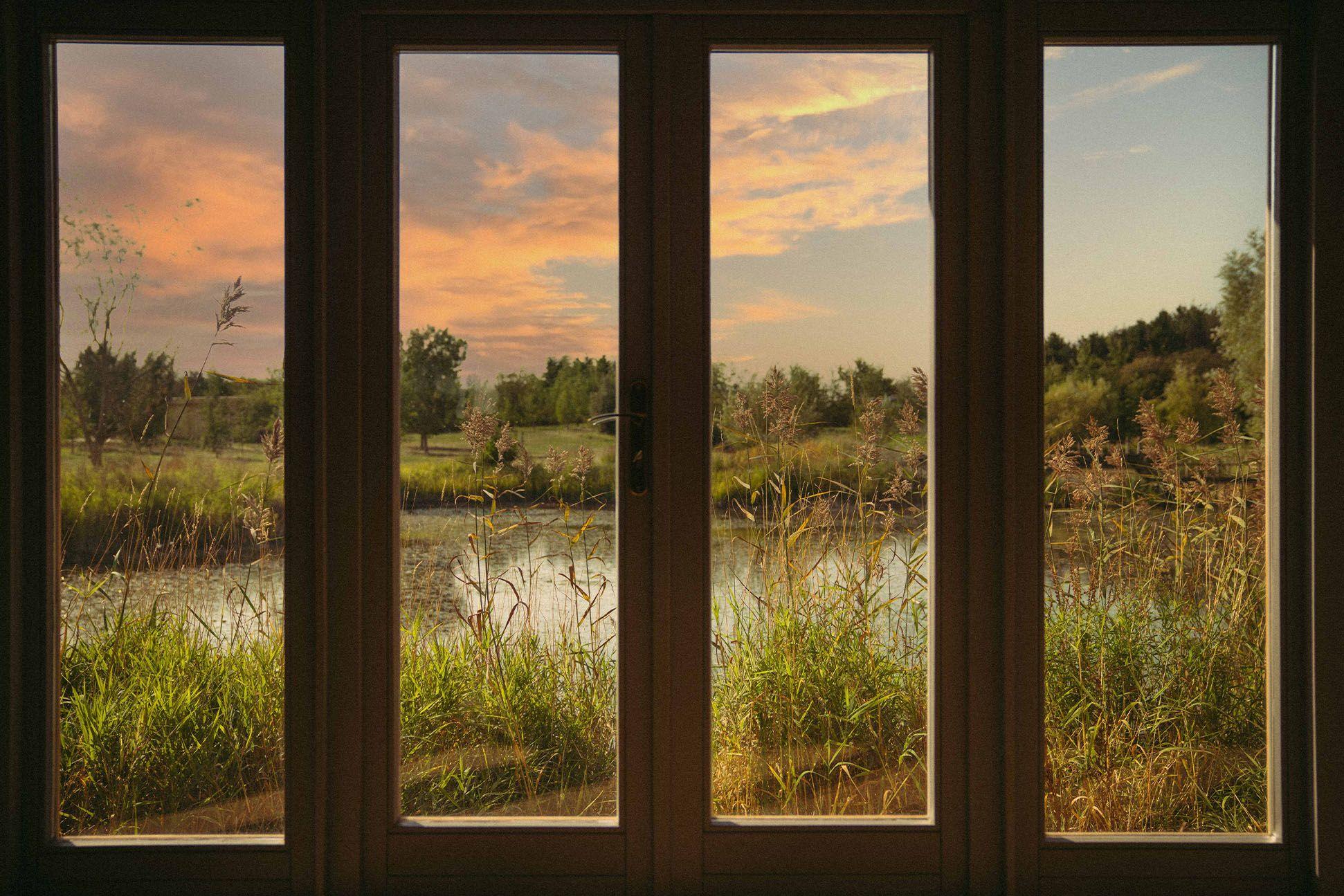 View out the windows of a cabin over a lake