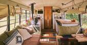 Interior with a wood burner, sofa, kitchen and dining area