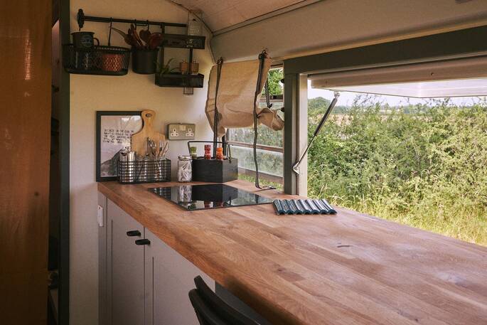 Kitchen equipped with an induction hob, undercounter fridge and cooking utensils