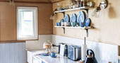 Kitchen equipped with a hob, kettle, oven, undercounter fridge and cooking utensils