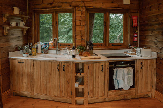 Kitchen equipped with an oven, induction hob, crockery, glassware and cooking utensils