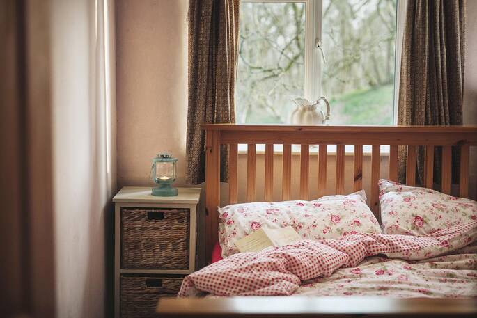 Tuck up in bed with a book at The Straw Cottage in Powys, Wales