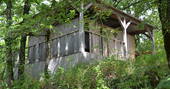 Exterior of wooden shower hut for guests to use at Le Camp in France 